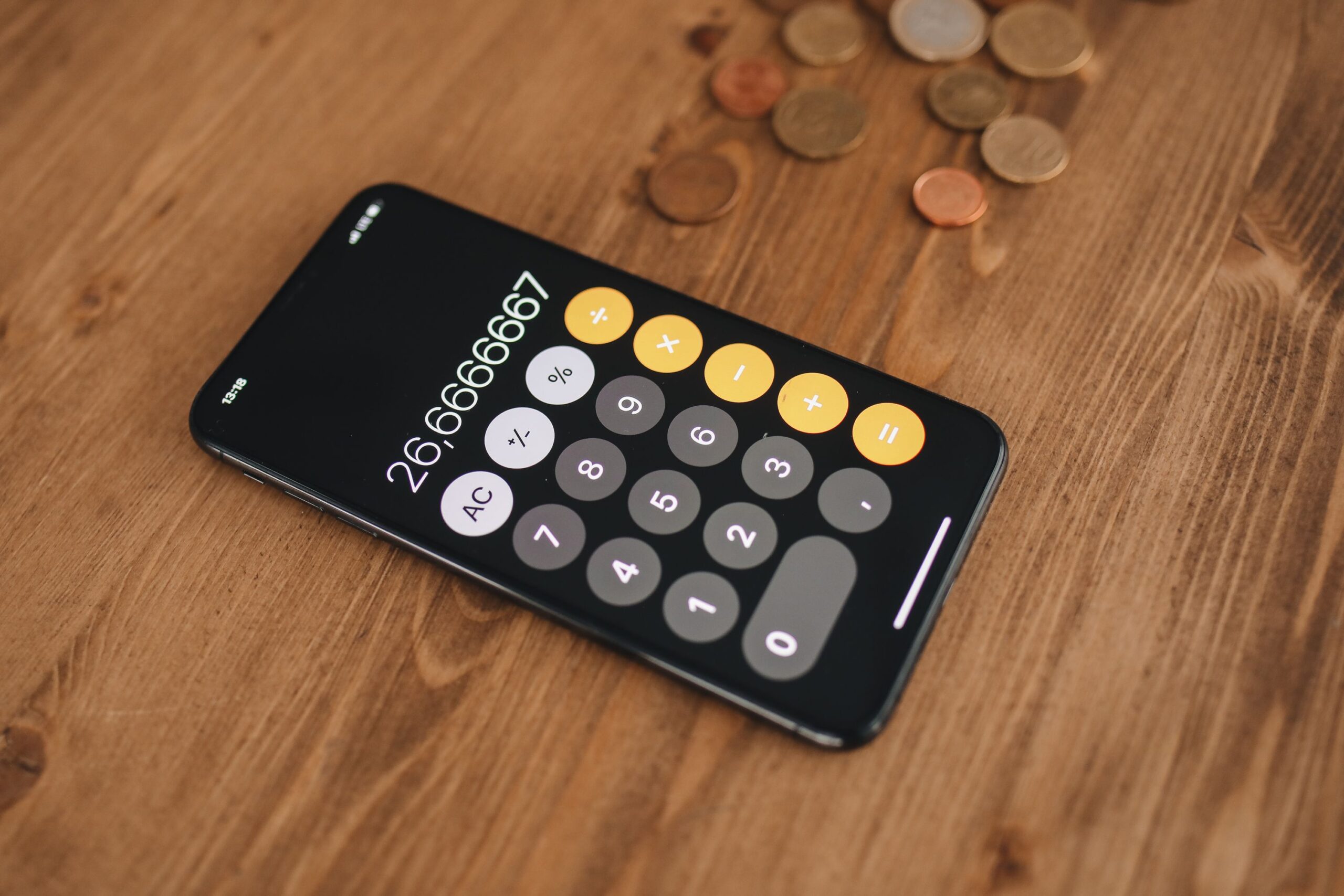 Smartphone and coins used to explain TikTok Coins pricing